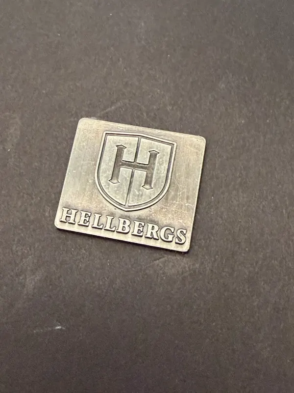 Hellbergs gjuten aluminiumskylt med djup gravyr och antik patinering